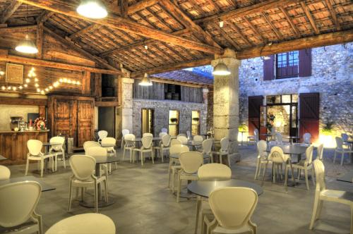 une pièce avec des tables et des chaises dans un bâtiment dans l'établissement Gîtes du Domaine des Dames, à Vallon-Pont-dʼArc
