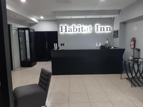 a waiting room with a black counter and a chair at Habitat Inn in Tapachula