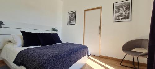 um quarto com uma cama e uma cadeira em Chez Charles Centre-Parking privé-Hospices-Gare em Beaune