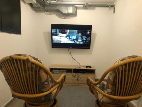 a living room with two chairs and a television at Kwatery Mińsk Mazowiecki in Mińsk Mazowiecki
