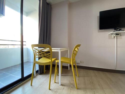 a room with a table and two chairs and a tv at Baansuay Rattanathibet Apartment in Nonthaburi