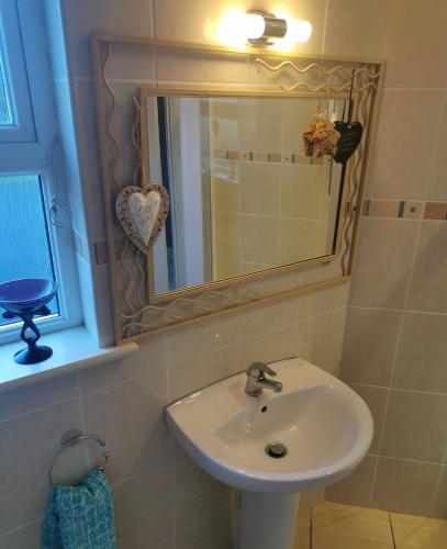 a bathroom with a sink and a mirror at Greenmile House, in Kilmeaden