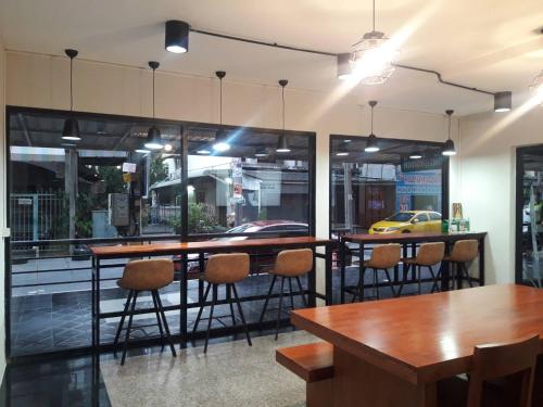 um restaurante com mesa e cadeiras e um táxi amarelo em Baansuay Rattanathibet Apartment em Nonthaburi