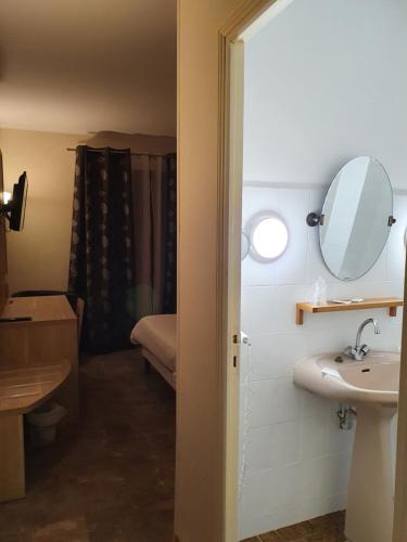 een badkamer met een wastafel en een spiegel bij Auberge de la Tour -Appartements- in Valros