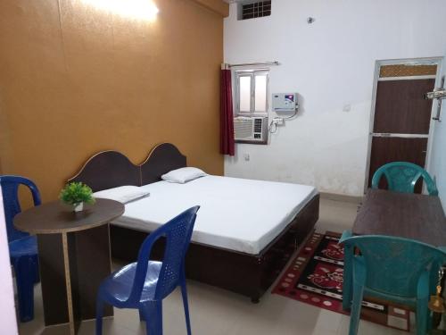 a room with a bed and a table and chairs at vindhyvasini guest house in Kushinagar