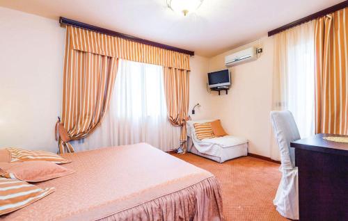 a bedroom with a bed and a chair and a television at Bed & Breakfast Valentina in Metajna
