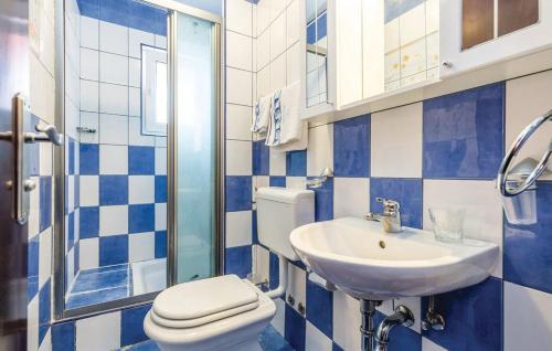 a blue and white bathroom with a toilet and a sink at Bed & Breakfast Valentina in Metajna