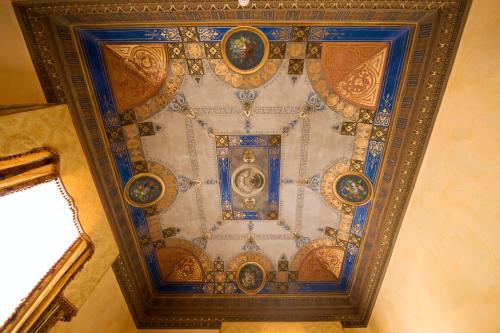 an ornate ceiling of a building with blue and gold at Hotel Joli in Palermo