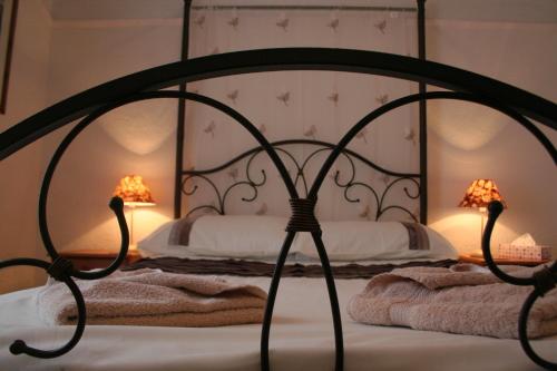 a bedroom with a bed with two lamps on it at The Haldon Guest House in Paignton