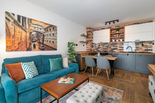 a living room with a blue couch and a kitchen at INCANTO in Ruse