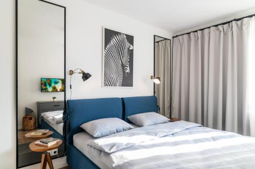 a bedroom with a blue bed and a mirror at INCANTO Apartment in Ruse