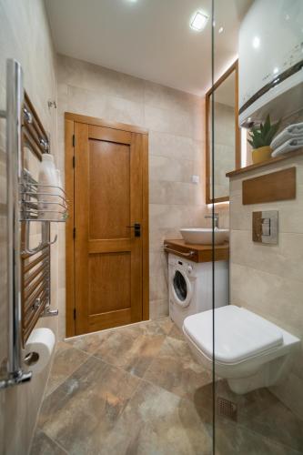 a bathroom with a toilet and a sink and a door at INCANTO Apartment in Ruse