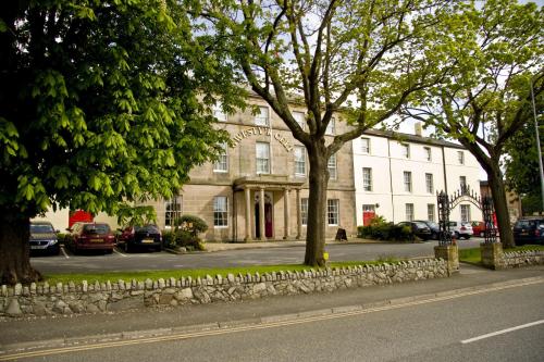 a building with trees in front of a street at The Celtic Royal Hotel in Caernarfon