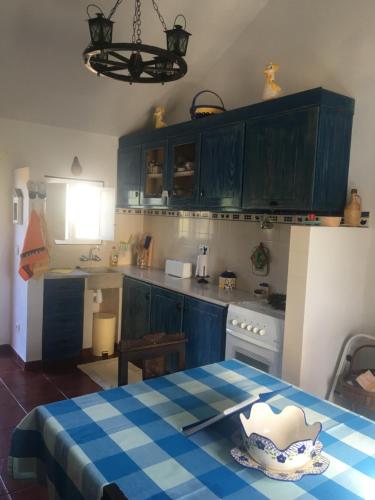 una cocina con armarios azules y una mesa con un plato. en Monte da Linda, 5 mins from Melides beach en Melides