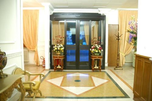 a lobby with a door with flowers on the floor at Hotel Flowers in Montecatini Terme