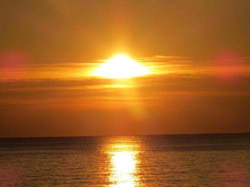 a sunset over the ocean with the sun in the sky at B&B Villino Giovanna Wi-Fi AC Prima fila mare Pineta in Porto SantʼElpidio