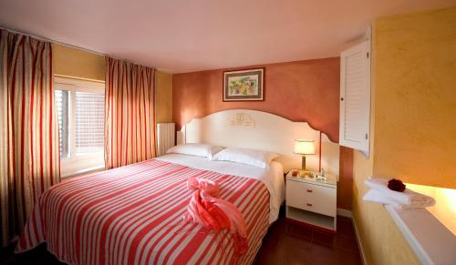 a hotel room with a bed with a red and white blanket at Hotel Joli in Palermo