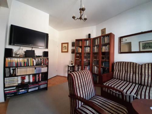 a living room with two chairs and a flat screen tv at Apartment History in Zagreb