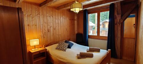 ein Schlafzimmer mit einem Bett in einem Zimmer mit einem Fenster in der Unterkunft LA JOLIE BERGERE in Morzine