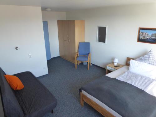 ein Hotelzimmer mit einem Bett und einem Stuhl in der Unterkunft Ferienwohnung Zollernblick in Tübingen