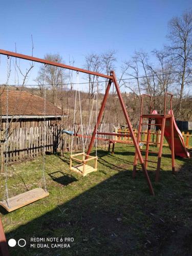 a playground with a swing set in a yard at Seosko turističko domaćinstvo MILKA in Čačak