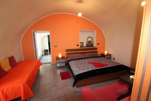a bedroom with a bed and an orange wall at Due Passi dal Mare in Ceriale