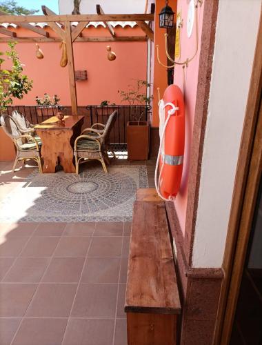 a wooden bench on a patio with a table and chairs at La Casona Canaria Boutique Home B & B in Agüimes