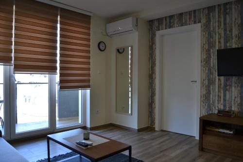 een woonkamer met een tafel en een klok aan de muur bij Apartman Alisa in Veliko Gradište