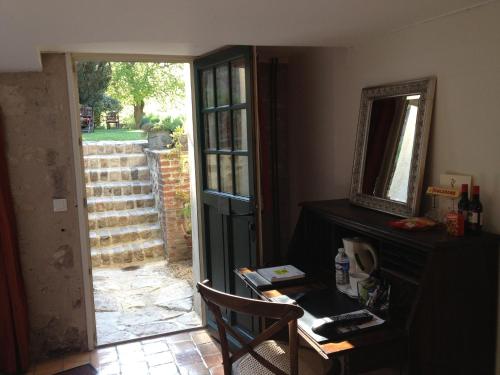 a room with a desk and a mirror and a door at Hotel L'Aunette Cottage in Chamant