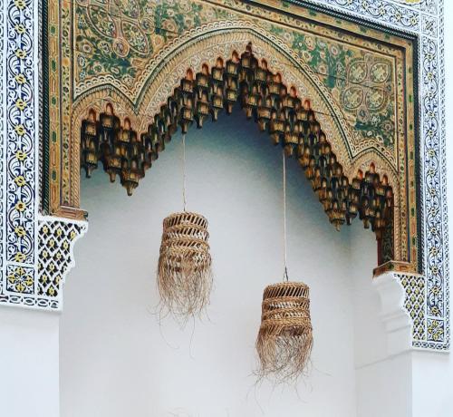 a room with two chandaliers hanging from a wall at Dar El Bali in Fez