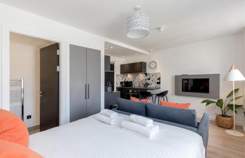 sypialnia z białym łóżkiem i salonem w obiekcie Destiny Scotland Market Street Apartments w Edynburgu