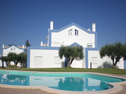 a large white house with a swimming pool in front of it at Casa Tedi, Alto do Perogil, Tavira - 3 Bedroom, 3 Bathroom villa, large Pool, exquisite Gardens & Air-conditioning in Tavira