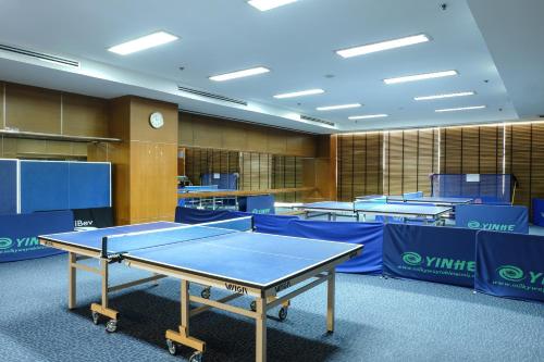 a ping pong table in a room with blue tables at The Twin Lotus Hotel in Nakhon Si Thammarat