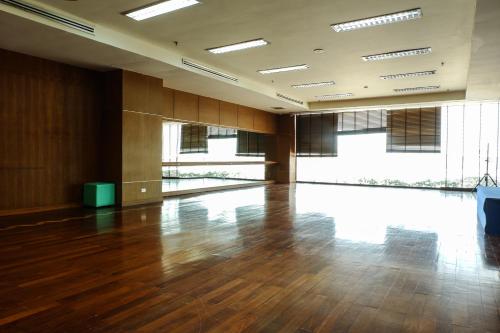 an empty room with a hard wood floor and windows at The Twin Lotus Hotel in Nakhon Si Thammarat
