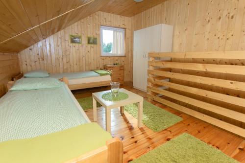 a room with two beds and a table in a cabin at Kompleks Wypoczynkowy Bryza II in Lubiatowo