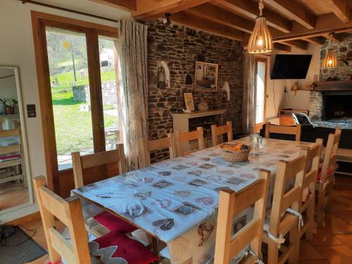 a dining room with a table and chairs and a room with a fireplace at La Grange Des Biches in Benque-Dessous-et-Dessus