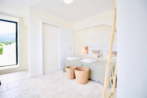 biała sypialnia z łóżkiem i dużym oknem w obiekcie Fish House 3 w mieście Prainha de Cima