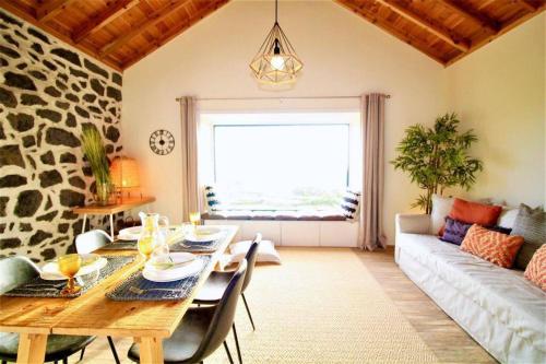 a living room with a table and a couch at Fish House 3 in Prainha de Cima