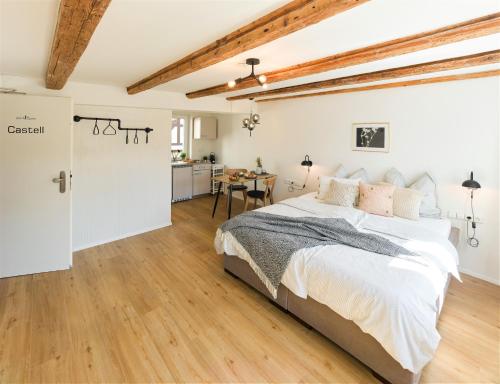 ein weißes Schlafzimmer mit einem Bett und einer Küche in der Unterkunft WachtRaum Reutlingen - Altstadt Apartment & Design Rooms an Stadthalle & Marktplatz in Reutlingen