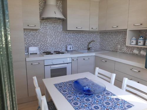 a kitchen with a table with a blue plate on it at I Tre Laghi Countryhouse 14 posti letti Cottage 10 posti letti in Citta' Sant'Angelo