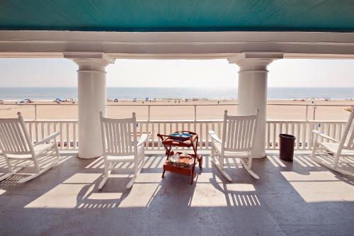 a porch with chairs and a table on the beach at Lankford Hotel and Lodge in Ocean City