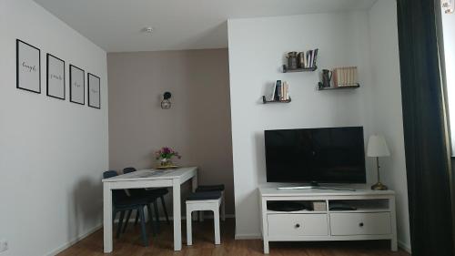 a living room with a tv and a table with chairs at Pura Vida - Allgäu in Bad Wurzach
