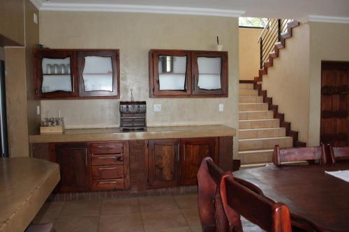 a kitchen with a table and a staircase in a room at Euphoria Self Catering Home in Naboomspruit