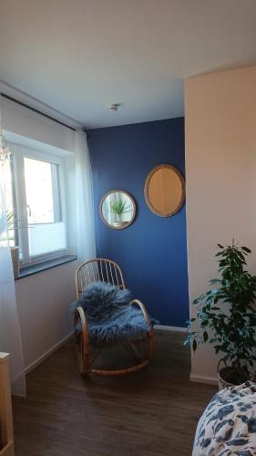 a blue room with a chair and two mirrors at Pura Vida - Allgäu in Bad Wurzach