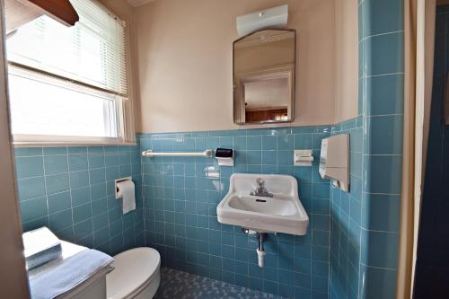 a blue tiled bathroom with a sink and a toilet at Lankford Hotel and Lodge in Ocean City