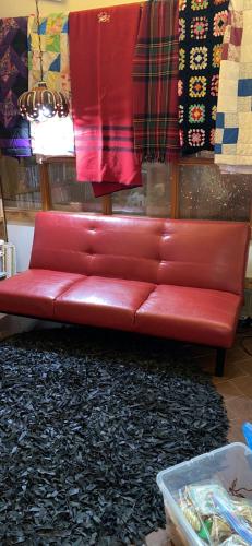 a red leather couch in a room with a rug at The Old Church B&B in Warner