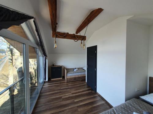 a bedroom with wood floors and a sliding glass door at Chatka Panorama in Mlynčeky