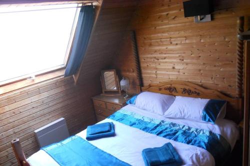 a bedroom with two beds in a wooden room at 3 Bedroom Lodge over looking Lake Dathee & Golf Course in Saint-Manvieu-Bocage