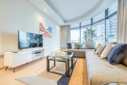 een woonkamer met een bank en een tv bij RH- Upscale Living in the Heart of the City, 02BR, Near Dubai Mall in Dubai