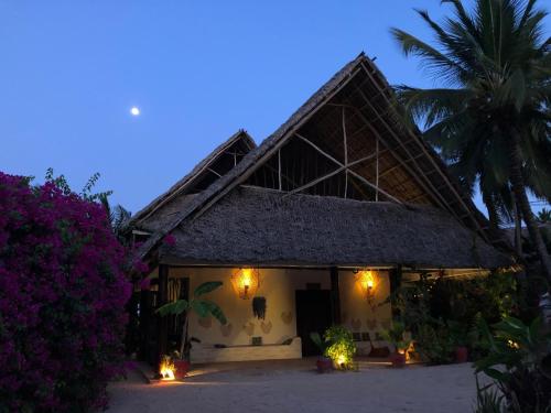 a house with lights in front of it at night at Tamani Villas in Matemwe